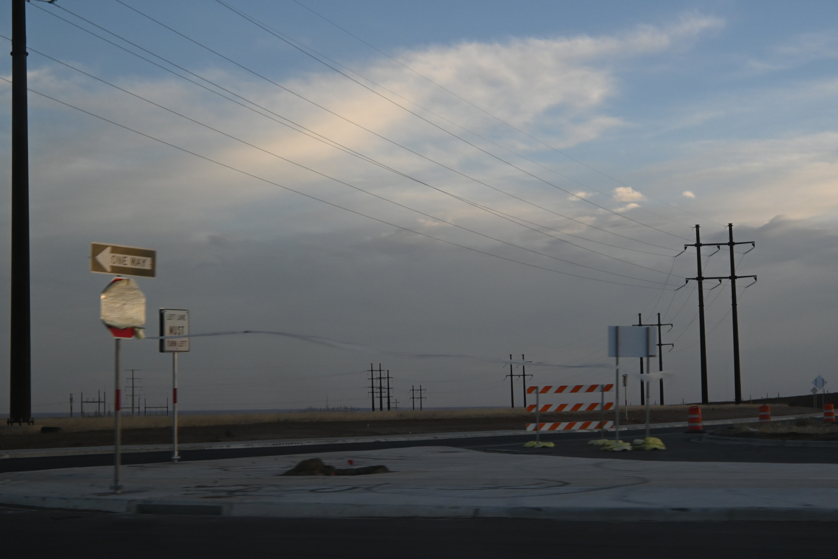 color photo of a horizon, with a stop sign in the foreground wrapped in plastic that is billowing out